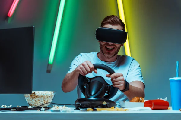 Gutaussehender Mann mit Virtual-Reality-Headset und Lenkrad — Stockfoto