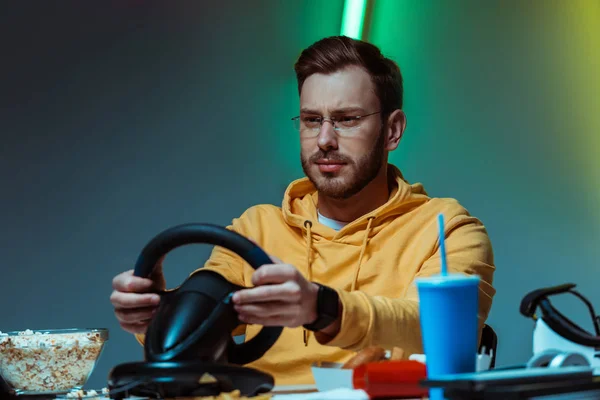 Hombre guapo y guapo en gafas jugando con el volante — Stock Photo