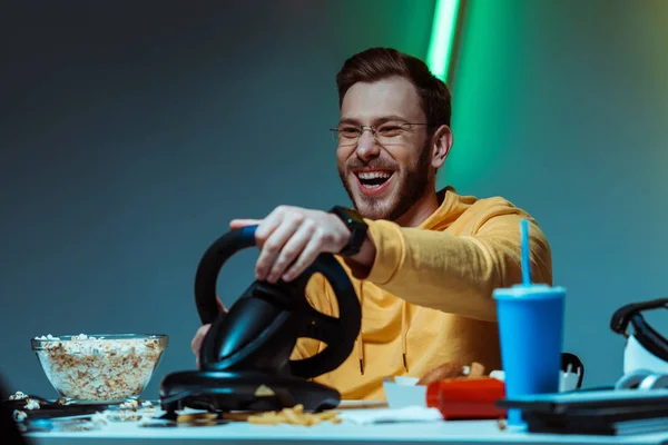 Smiling and good-looking man in glasses playing with steering wheel — Stock Photo