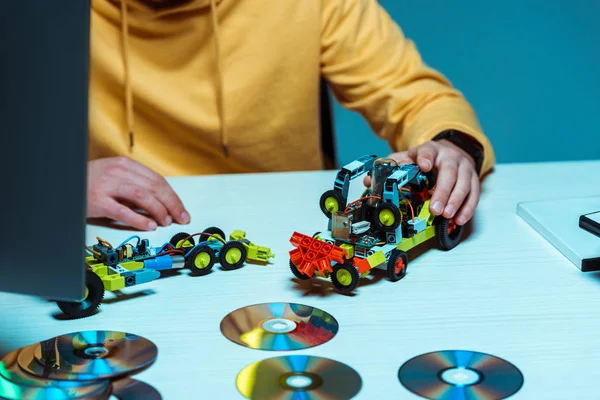 Вибірковий фокус людини, що грає з іграшковим автомобілем на білому столі — стокове фото