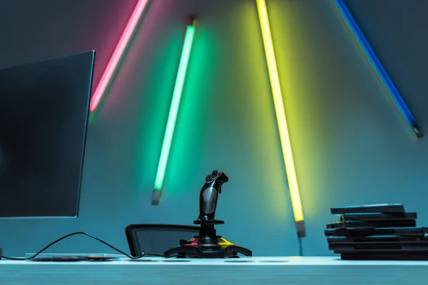 Computer monitor, joystick and compact disks with video games on table — Stock Photo