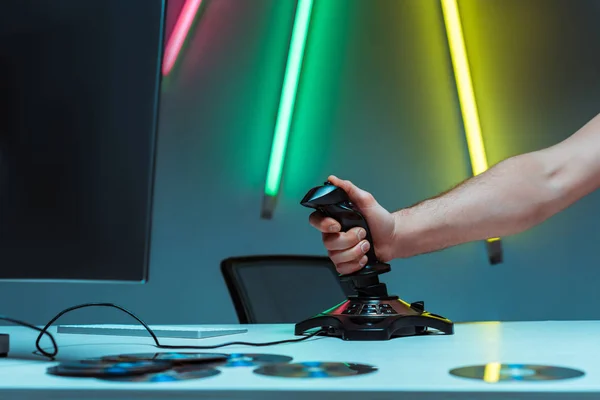 Partial view of man holding joystick on table in apartment — Stock Photo