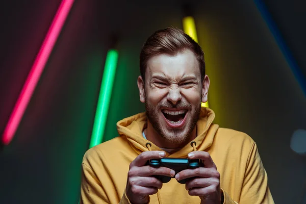 Handsome and screaming man looking at camera and holding gamepad — Stock Photo