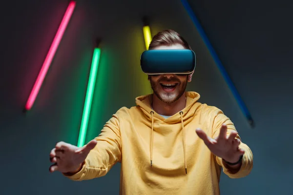 Adulto joven y hombre guapo jugando en auriculares de realidad virtual - foto de stock