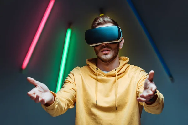 Triste jovem adulto e bonito homem jogando no fone de ouvido realidade virtual — Fotografia de Stock