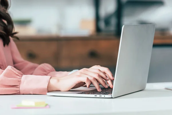 Vista cortada da menina na camisa rosa digitando no teclado do laptop — Fotografia de Stock