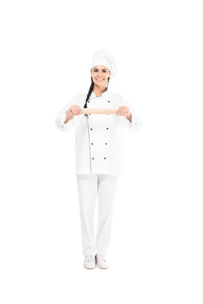 Vista completa dello chef in cappello tenendo il mattarello isolato sul bianco — Foto stock