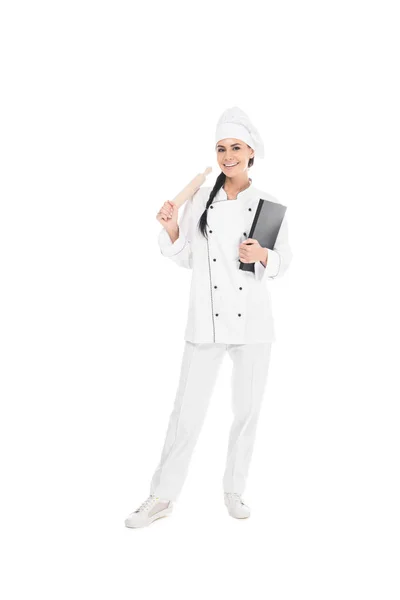 Visão de comprimento total do chef em chapéu segurando rolo e livro isolado em branco — Fotografia de Stock