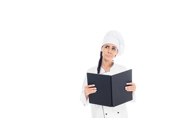 Sad chef in uniform holding black book isolated on white — Stock Photo