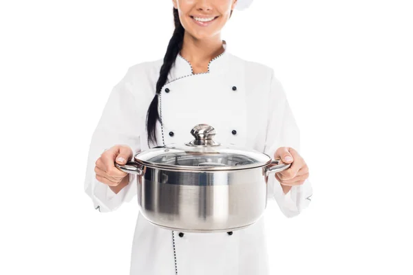 Vue partielle du chef souriant en uniforme tenant le pot en acier isolé sur blanc — Photo de stock