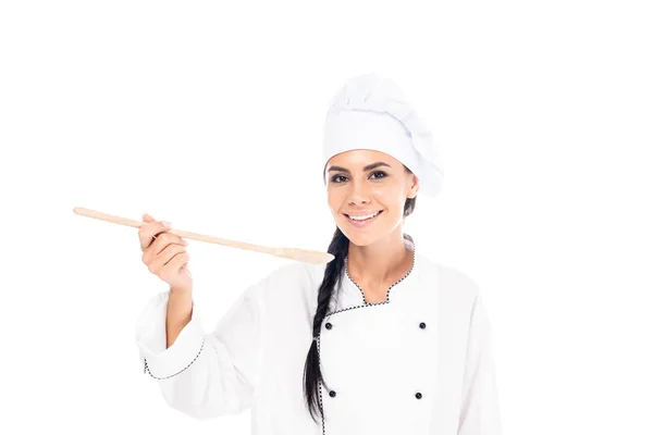 Chef sonriente con sombrero sosteniendo espátula de madera aislada en blanco - foto de stock