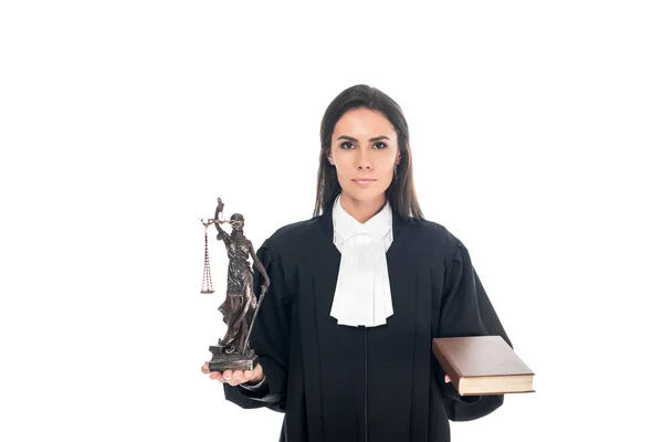 Juez en bata judicial sosteniendo themis estatuilla y libro aislado en blanco - foto de stock