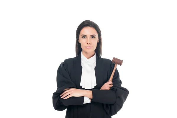 Juge en robe judiciaire tenant le marteau et debout avec les bras croisés isolés sur blanc — Photo de stock