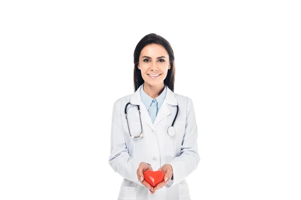 Доктор у білому пальто, що тримає пластикове серце ізольовано на білому — стокове фото