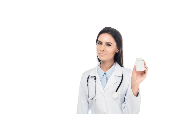 Врач в белом халате со стетоскопом держит таблетки изолированы на белом — стоковое фото