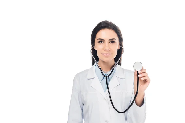 Hermoso médico en bata blanca usando estetoscopio aislado en blanco - foto de stock
