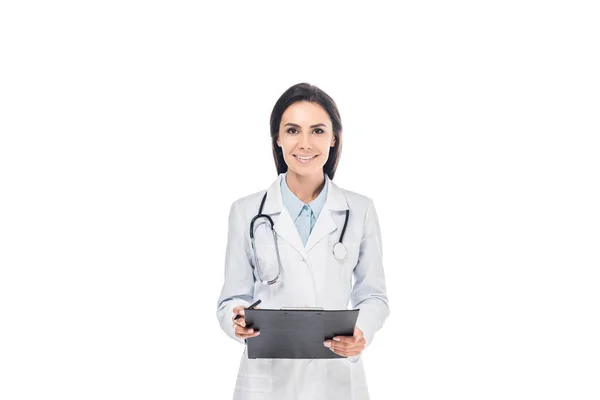 Smiling doctor in white coat holding clipboard isolated on white — Stock Photo