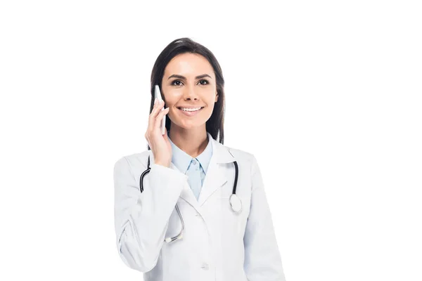 Доктор у білому пальто зі стетоскопом, що говорить на смартфоні ізольовано на білому — стокове фото