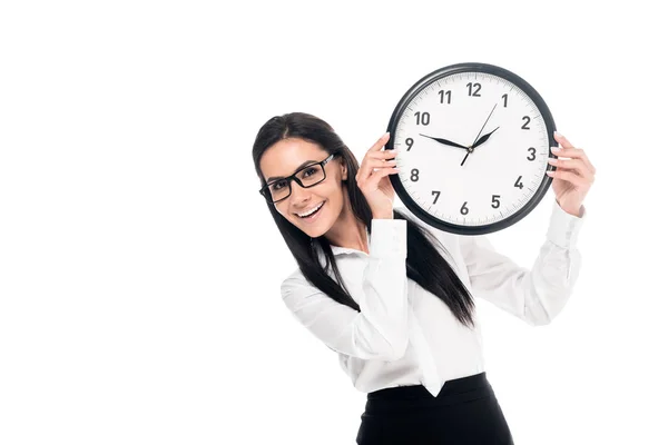 Femme d'affaires brune souriante en chemise tenant horloge isolé sur blanc — Photo de stock