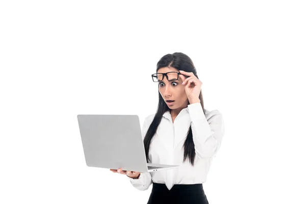 Femme d'affaires choquée dans des lunettes en utilisant un ordinateur portable isolé sur blanc — Photo de stock