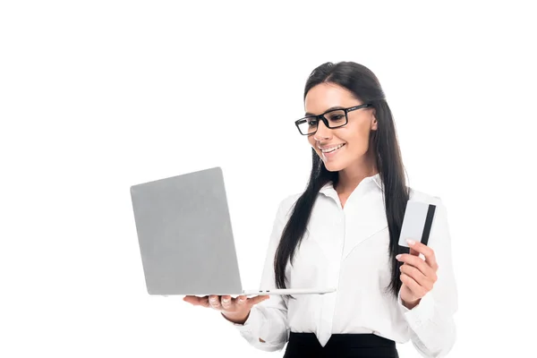 Empresária elegante em óculos segurando laptop e cartão de crédito isolado no branco — Fotografia de Stock