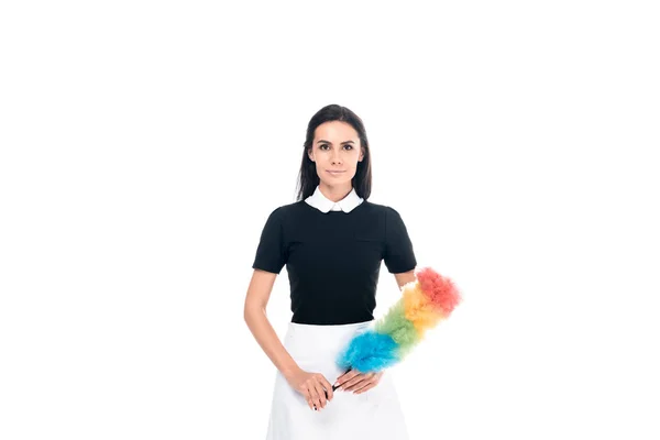 Brunette maid in uniform holding duster isolated on white — Stock Photo