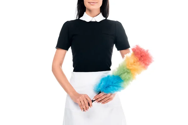 Cropped view of maid in uniform holding duster isolated on white — Stock Photo