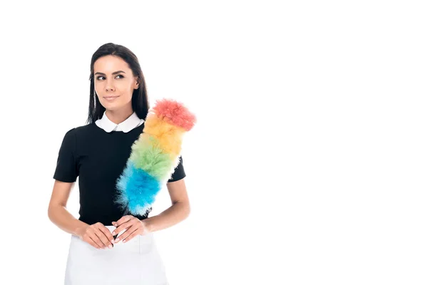 Brunette maid in uniform holding duster isolated on white — Stock Photo