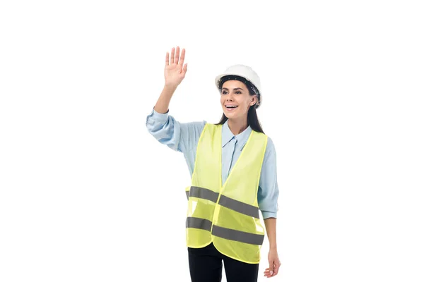 Ingeniero sonriente en chaleco de seguridad agitando la mano aislado en blanco - foto de stock