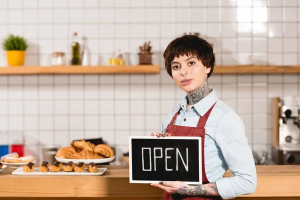 Attraktives Barista-Halteschild mit offenem Schriftzug und Blick in die Kamera — Stockfoto