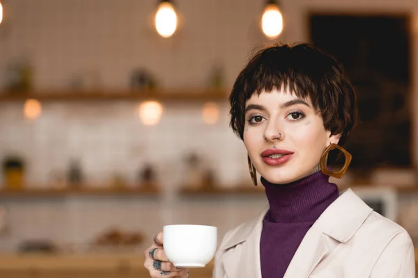 Schöne Geschäftsfrau mit Kaffeetasse, lächelnd und in die Kamera blickend — Stockfoto