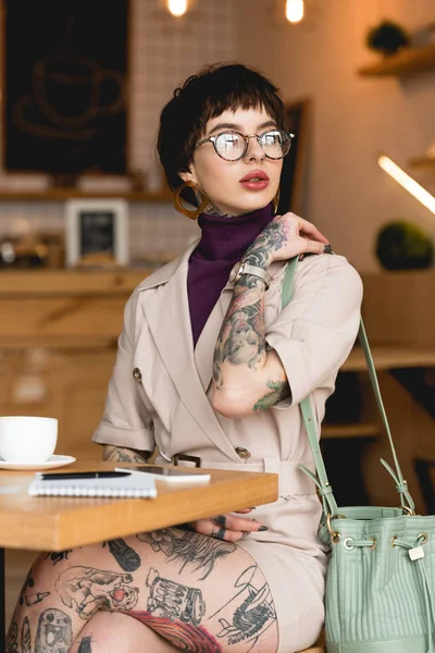 Bela, mulher de negócios na moda em óculos segurando saco e olhando para longe — Fotografia de Stock