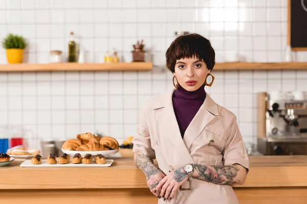 Schöne Geschäftsfrau steht in der Cafeteria neben der Theke und schaut in die Kamera — Stockfoto