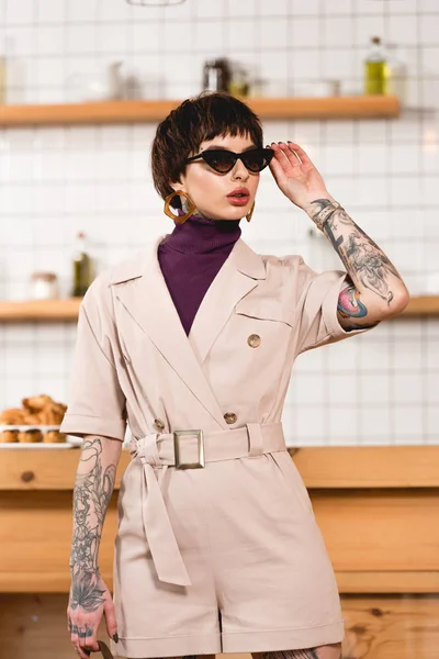 Bela empresária em óculos de sol em pé na cafetaria — Fotografia de Stock