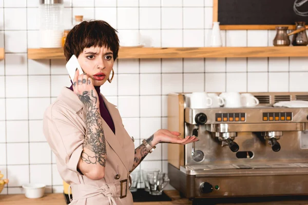 Attractive, surprised businesswoman talking on smartphone in cafeteria — Stock Photo