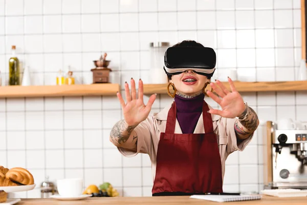 Barista souriant en réalité virtuelle casque debout près comptoir bar dans cafteria — Photo de stock