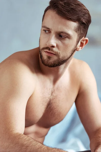 Gut aussehender, sexy, hemdloser und muskulöser Mann, der im Schlafzimmer wegschaut — Stockfoto