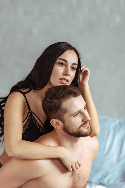 Sexy e caldo coppia abbracci e guardando lontano in camera da letto — Foto stock