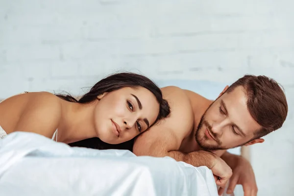 Приваблива жінка лежить в ліжку з красивим чоловіком в спальні — стокове фото
