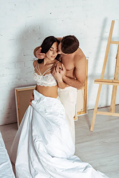 Handsome and sexy man hugging beautiful woman in lace bra in bedroom — Stock Photo