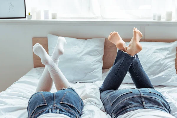 Обрезанный вид мужчины и женщины в джинсах и шортах в спальне — стоковое фото