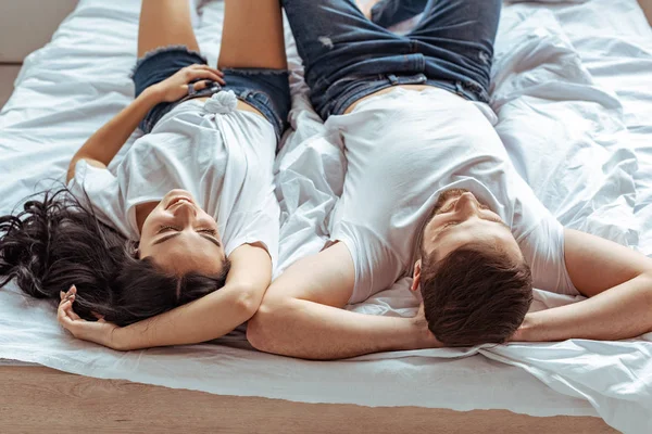 Handsome man and beautiful woman lying in bed and looking up — Stock Photo
