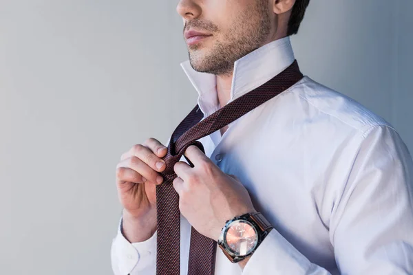 Partial view of confident man in white shirt putting tie on — Stock Photo