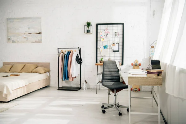 Chambre confortable avec grand lit et lieu de travail avec ordinateur portable — Photo de stock