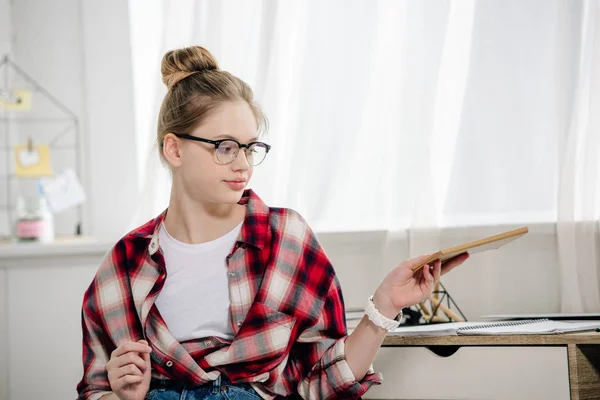 Adolescente em óculos e vermelho xadrez camisa segurando livro — Fotografia de Stock