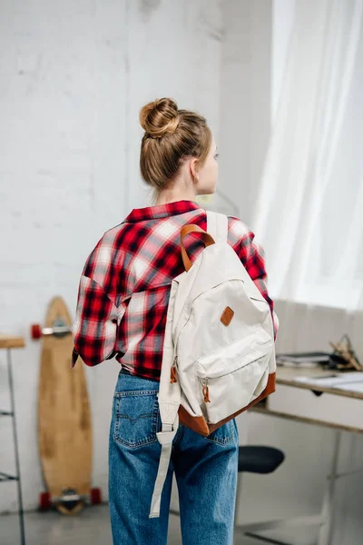 Back view of teenager in checkered shirt and jeans with backpack — Stock Photo
