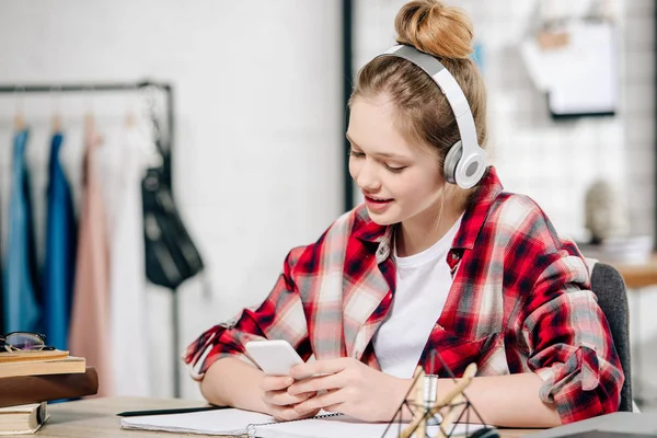 Joyful adolescente em vermelho xadrez camisa ouvir música em fones de ouvido — Fotografia de Stock