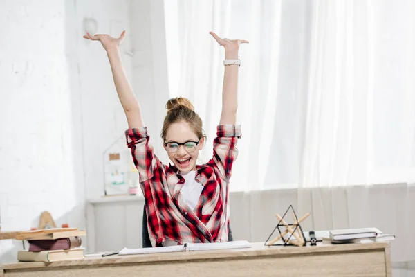 Adolescente feliz em óculos e camisa quadriculada rindo da mesa — Fotografia de Stock