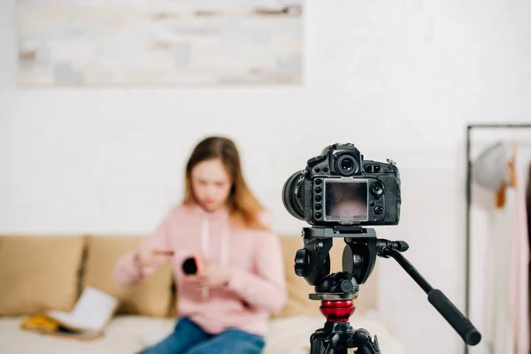 Foco seletivo do blogueiro adolescente sentado na frente da câmera de vídeo — Stock Photo