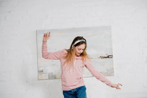 Adolescent enfant écouter de la musique dans les écouteurs et danser dans la chambre — Photo de stock